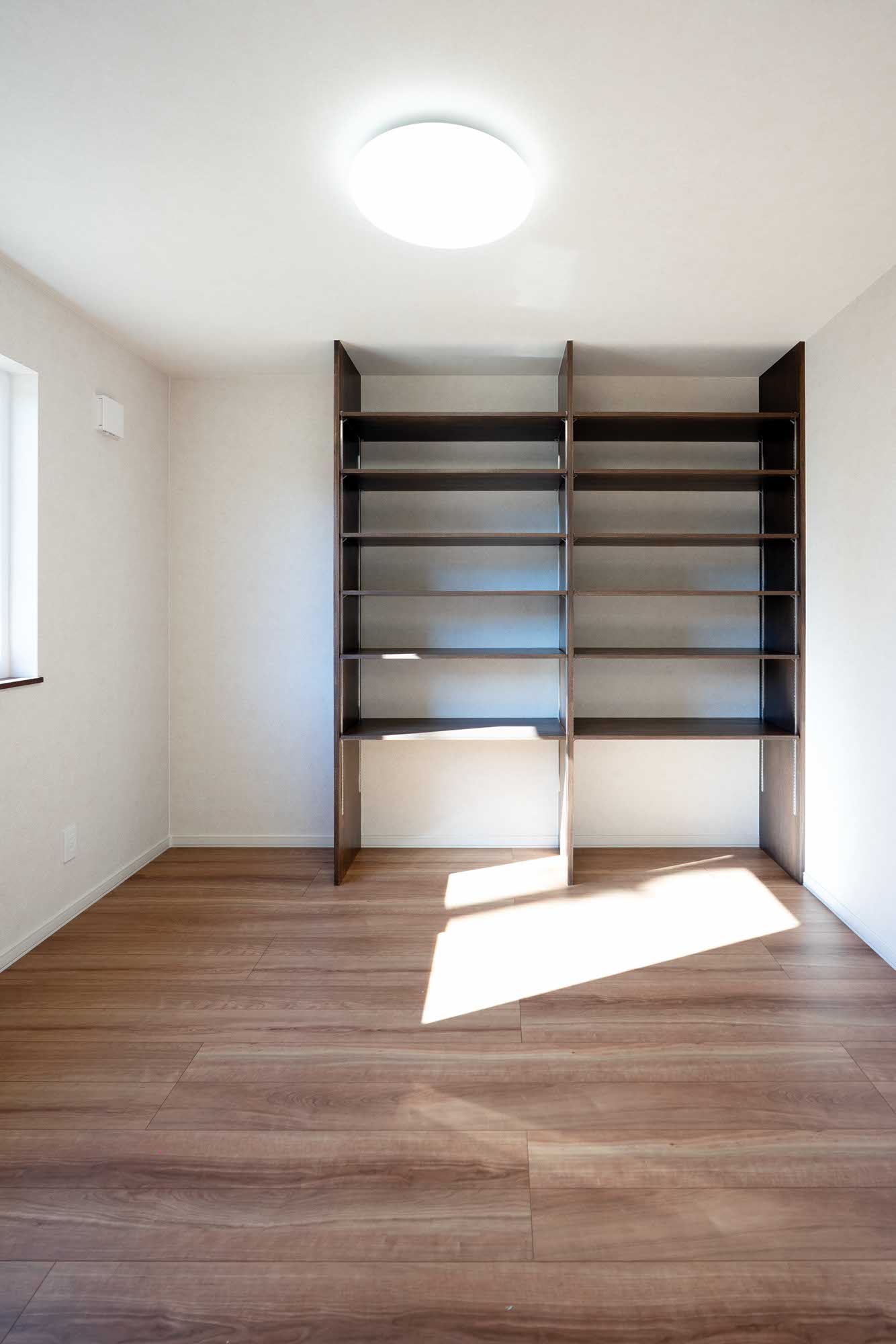 リビングとつながる開放的な続き間には大きな本棚を設置